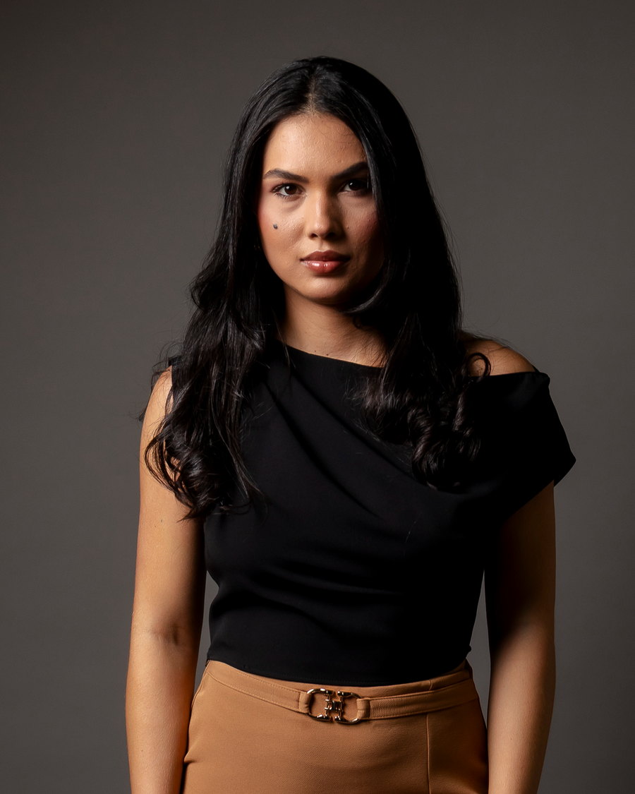 Retrato da Dra. Elaine Pereira, de blusa preta, olhando para a câmera